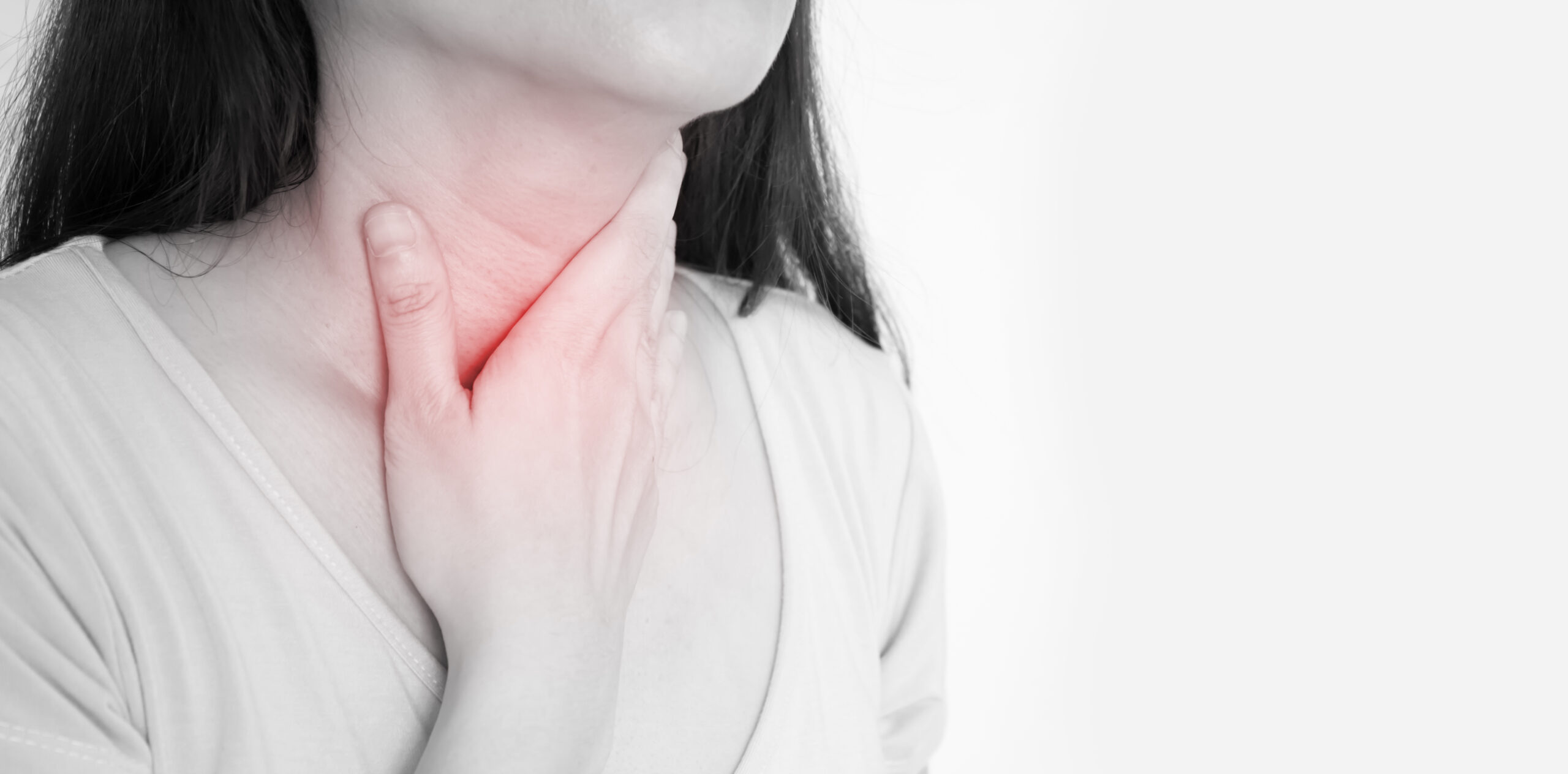 Image of a woman with her hand on her neck/thyroid, representing thyroid cancer awareness and diagnosis